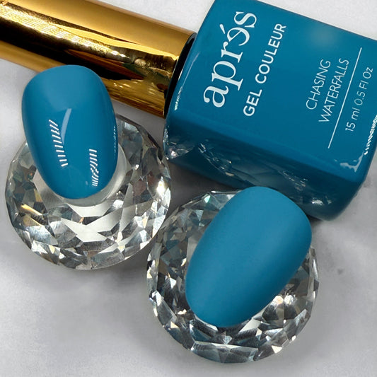 Blue nail polish bottle with matching nails showing matte and glossy topcaot on a white background