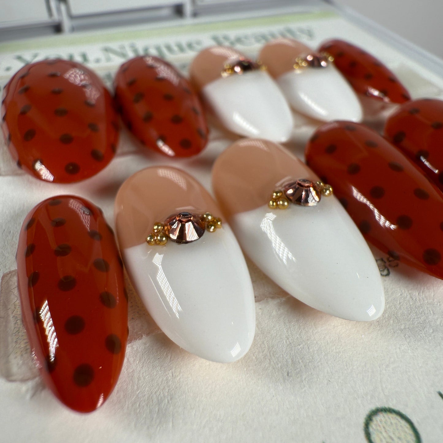 Set of nail art designs on a white surface with visible brand name.