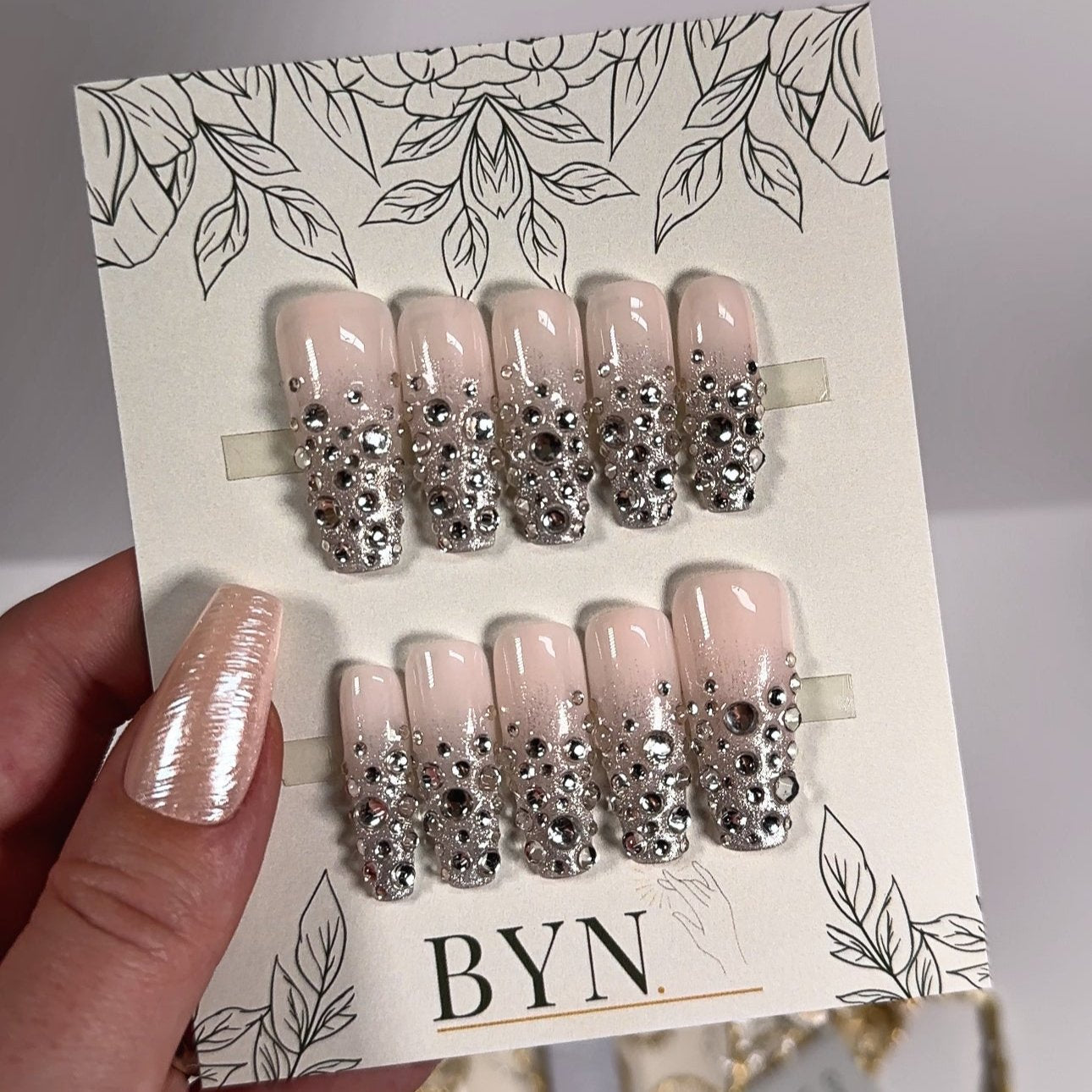 Custom hand-painted reusable stick-on nails featuring a stunning silver ombre fade design, embellished with sparkling crystals and gems for an elegant and glamorous look.