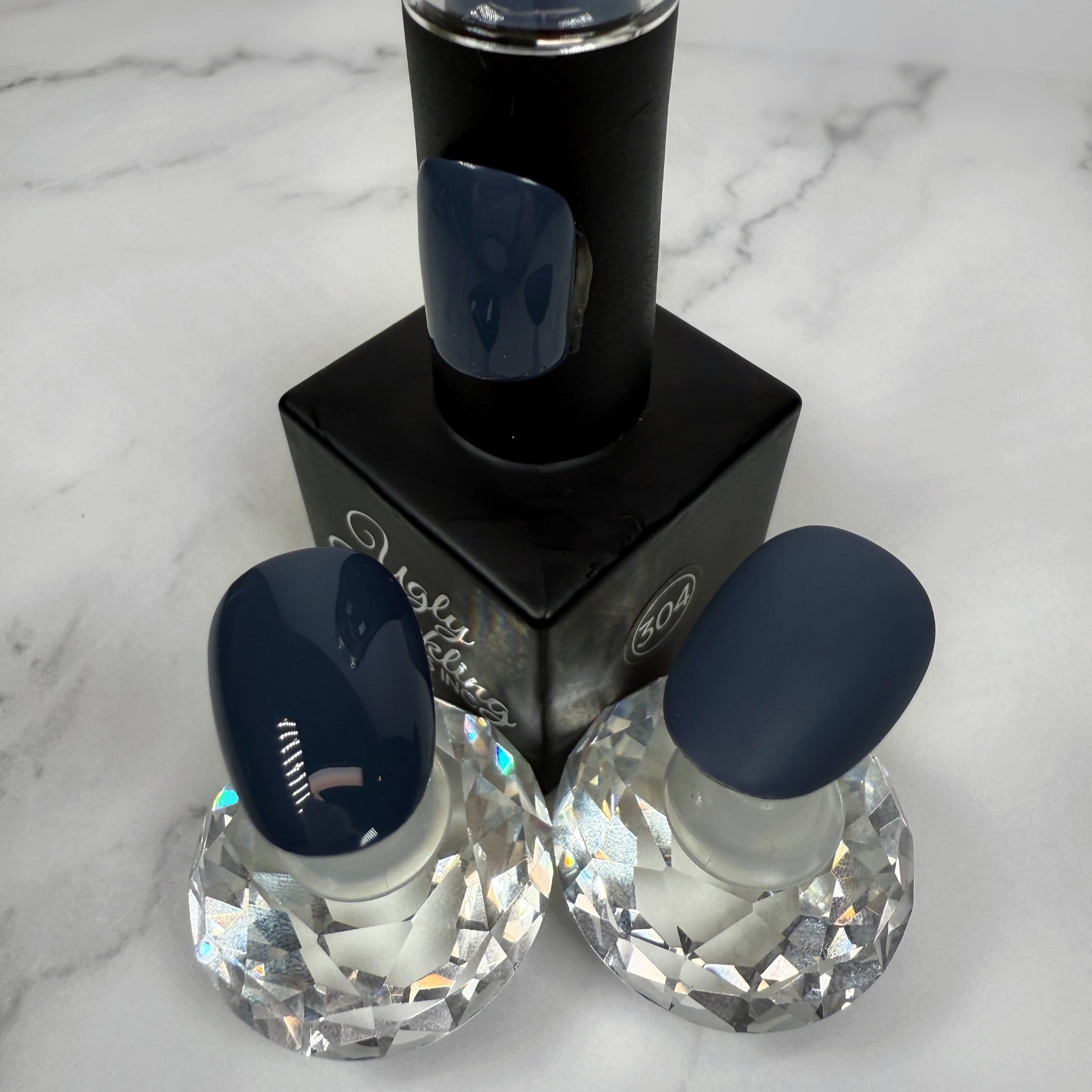 Nail polish bottle with two sample nails showing glossy and matte topcoat