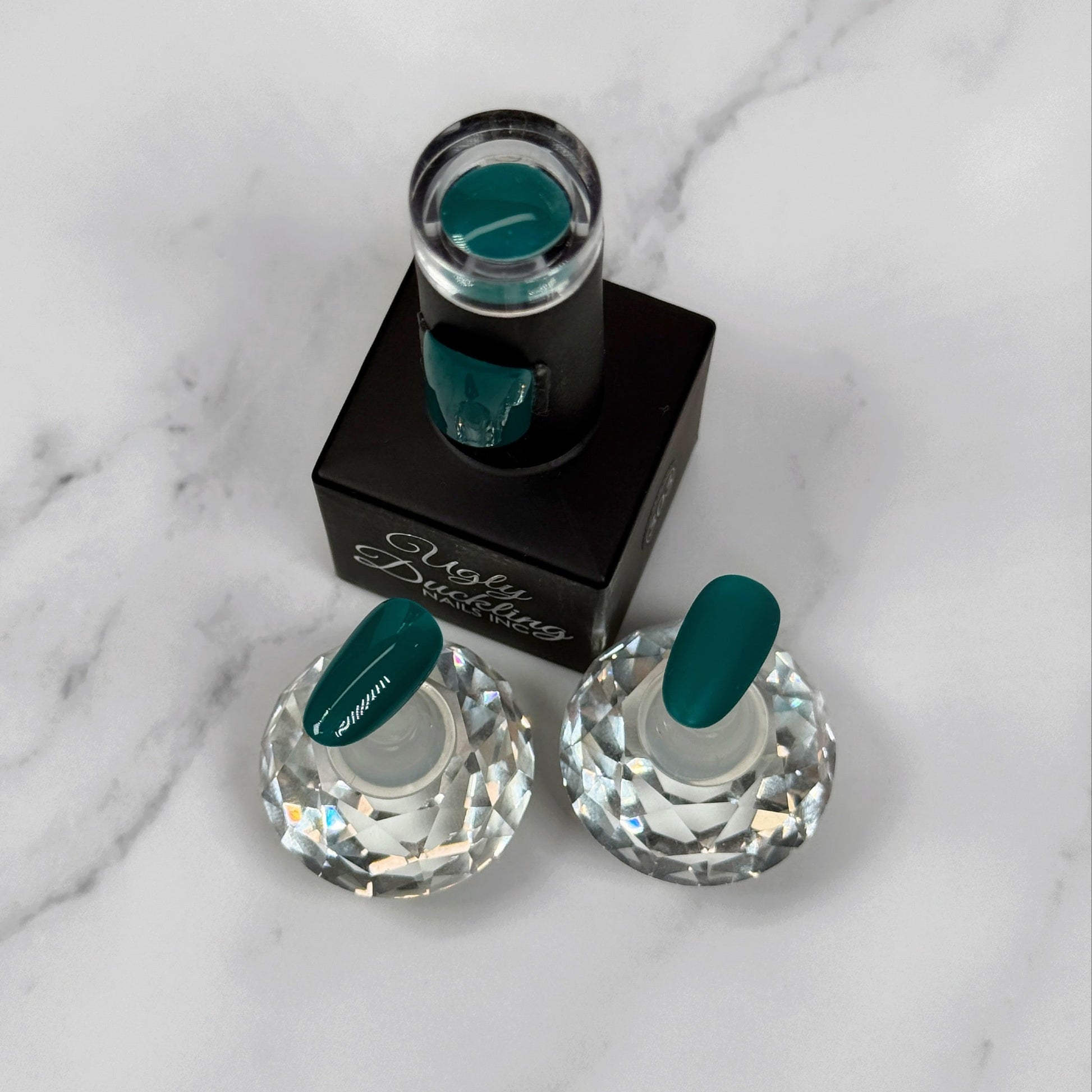 Teal Nail polish in the bottle with two sample nails showing the difference between matte and glossy topcoat