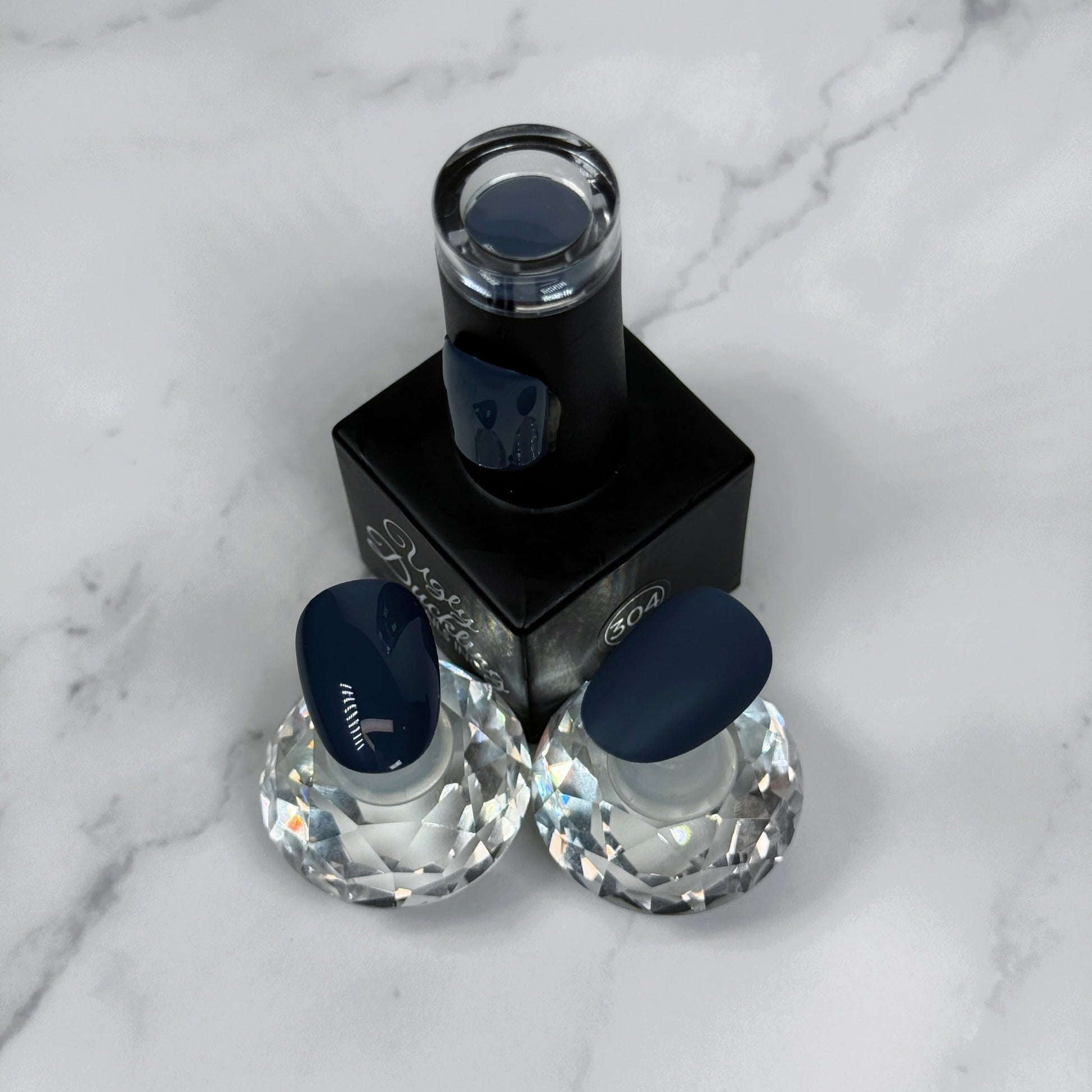 Nail polish bottle with two sample nails showing glossy and matte topcoat