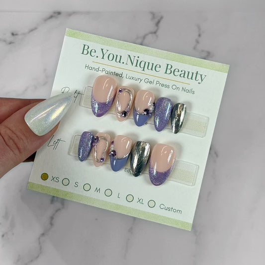 It's HER elevated spring press-on nail set with lavender cat eye nails hand painted chrome details and gem accents handmade in Canada by BYN Beauty