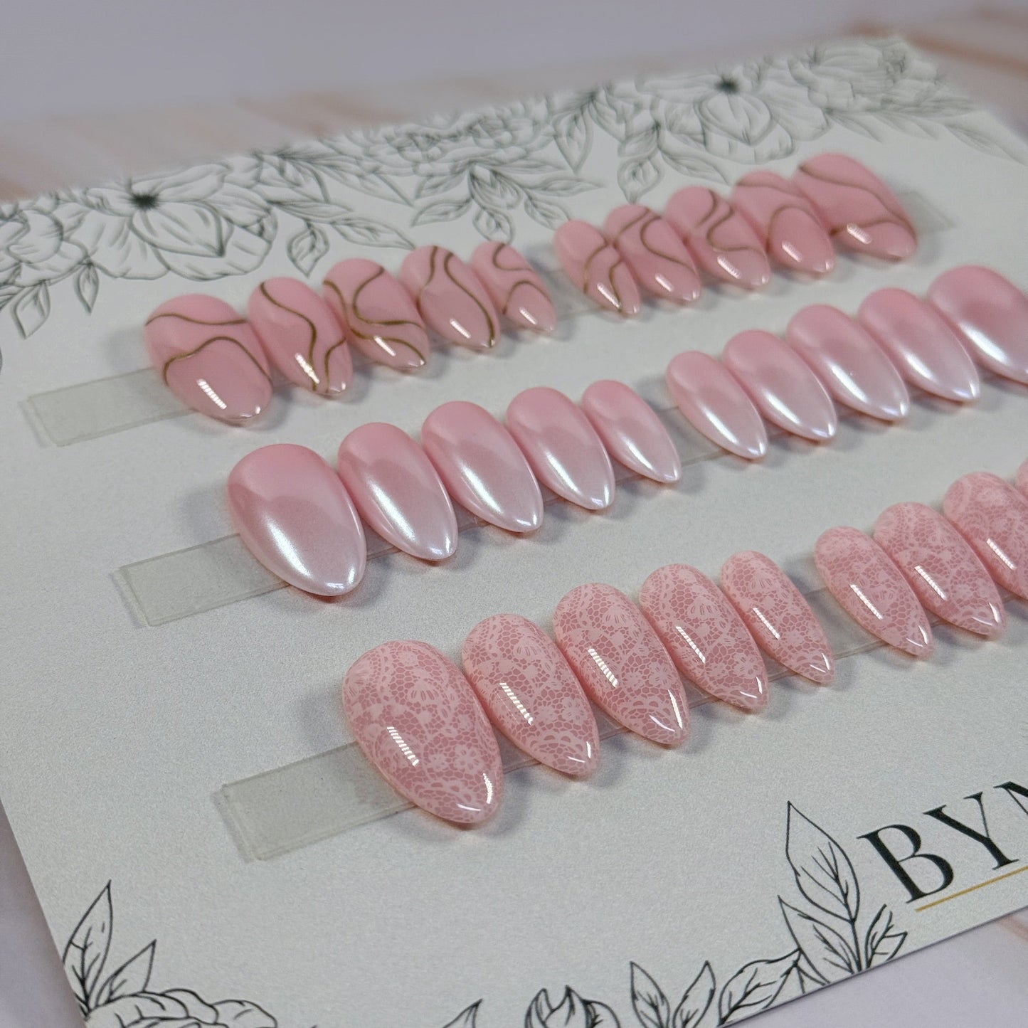 3 sets, a neutral with gold swirls, a chrome french fade and a neutral with subtle lace