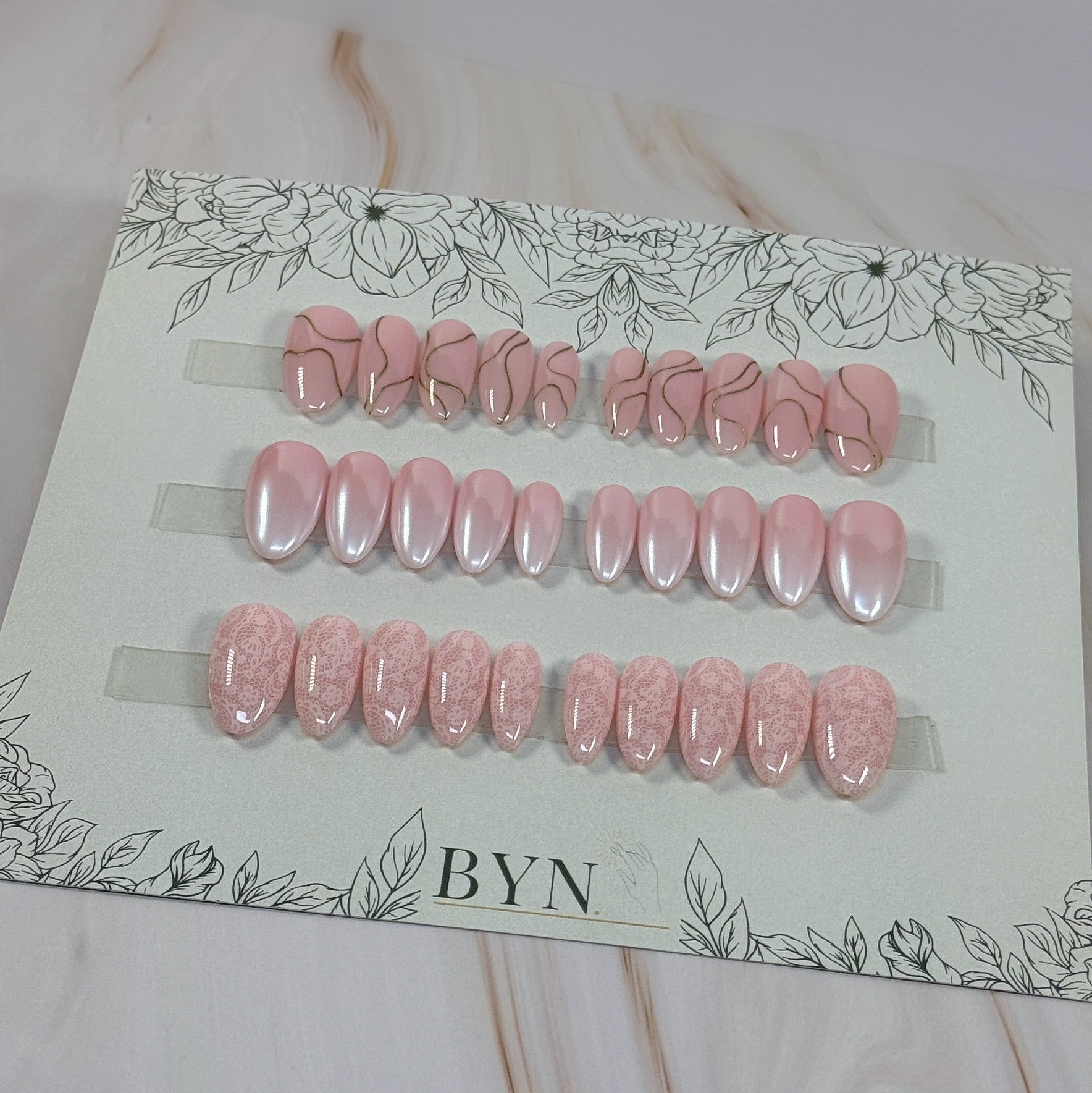 3 sets, a neutral with gold swirls, a chrome french fade and a neutral with subtle lace