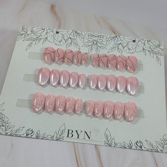 3 sets, a neutral with gold swirls, a chrome french fade and a neutral with subtle lace