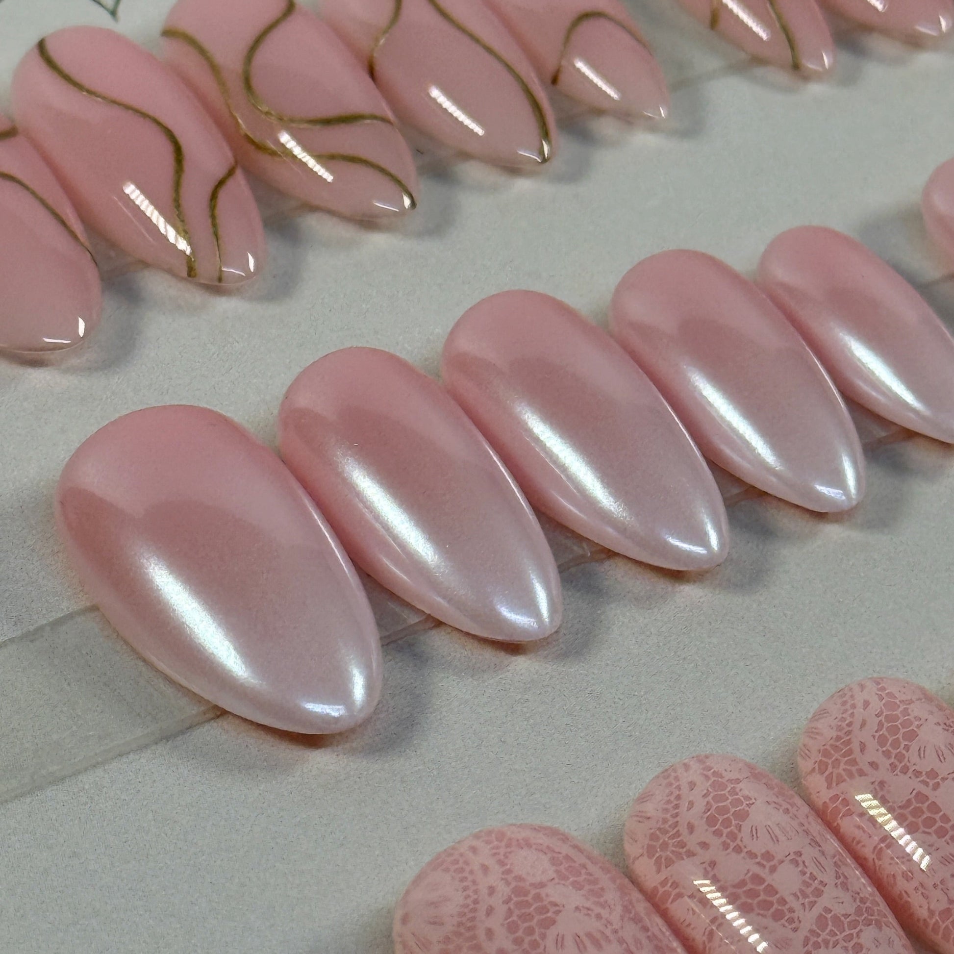 3 sets, a neutral with gold swirls, a chrome french fade and a neutral with subtle lace